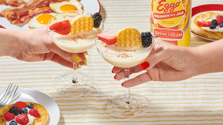 Two people clinking cocktail drinks
