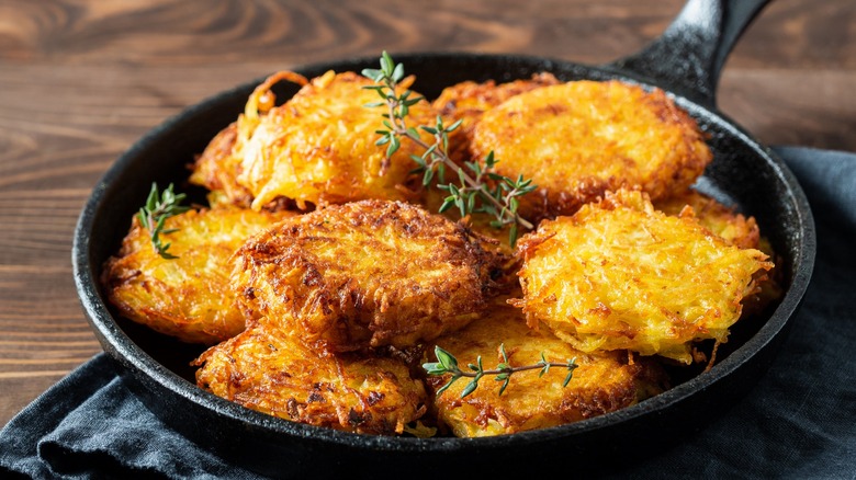 Cast iron pan full of hash brown patties