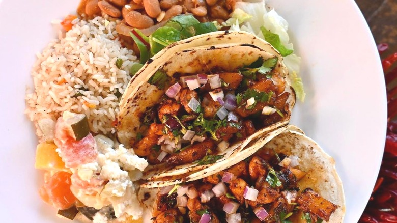 Tacos on a plate with rice and beans