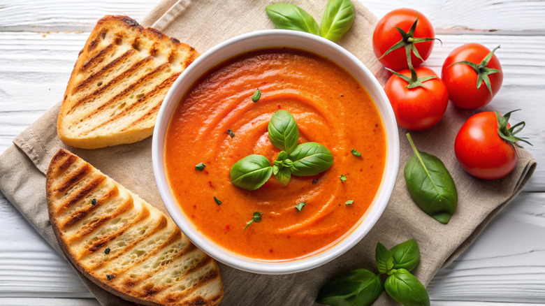 A bowl of creamy tomato soup with basil