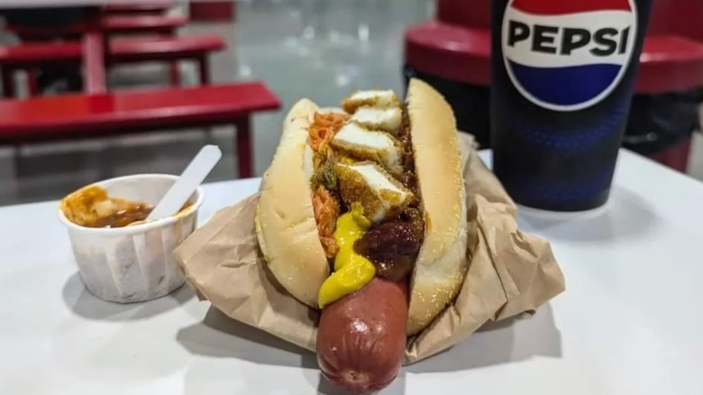 Costco hot dog garnished with free samples.