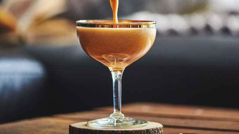 pouring espresso martini from cocktail shaker