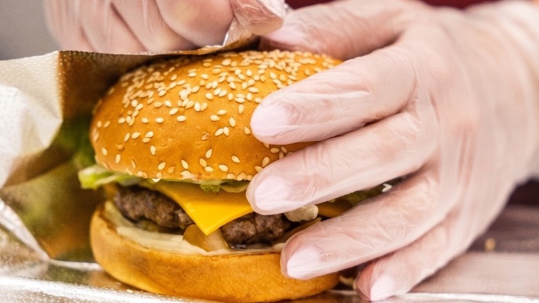 Five Guys employee wrapping a burger.