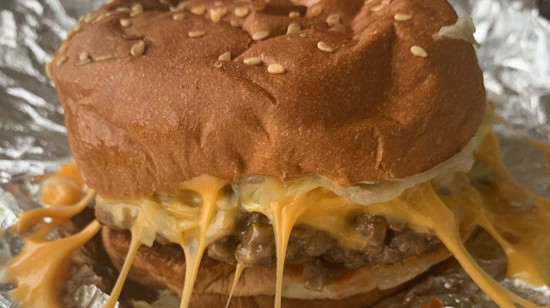 A Five Guys burger with lots of cheese and mushrooms.