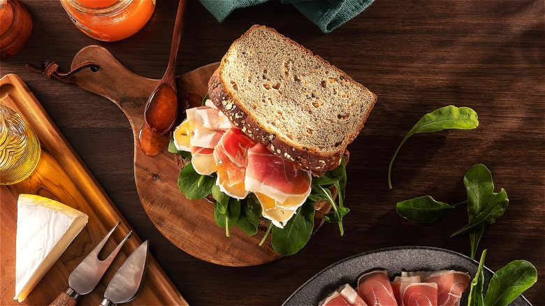 Ham sandwich with greens and jam on multigrain bread