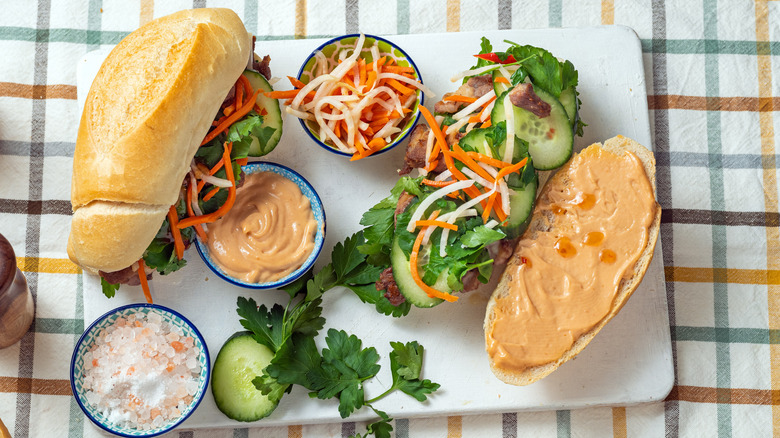 Banh mi sandwich ingredients sit on a stone slab