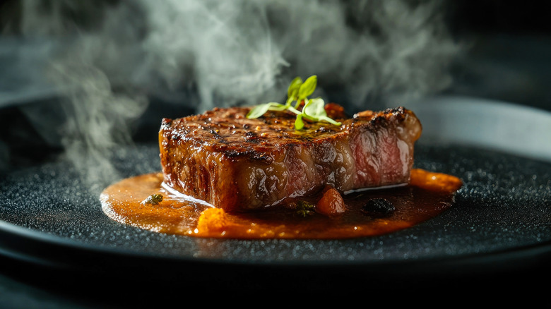 A steaming steak sitting in a bed of savory sauce