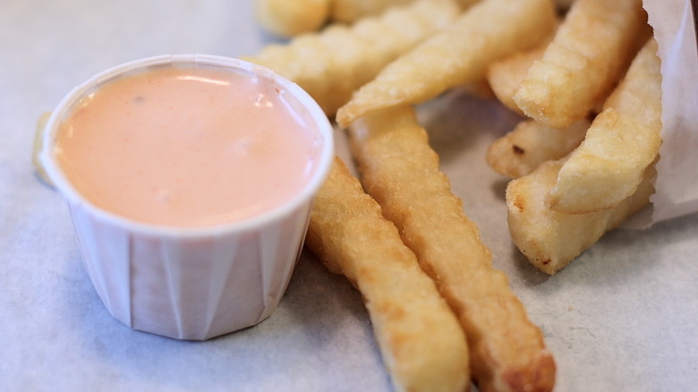 A container of fry sauce sits next to french fries