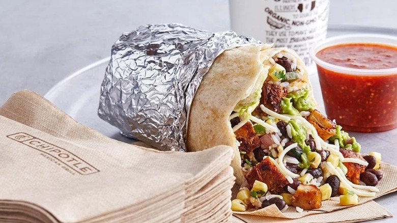 A steak burrito, drink, and a side of salsa from Chipotle