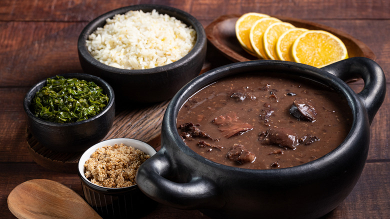 A Brazilian feijoada completa with bean stew, rice, kale, and farofa.