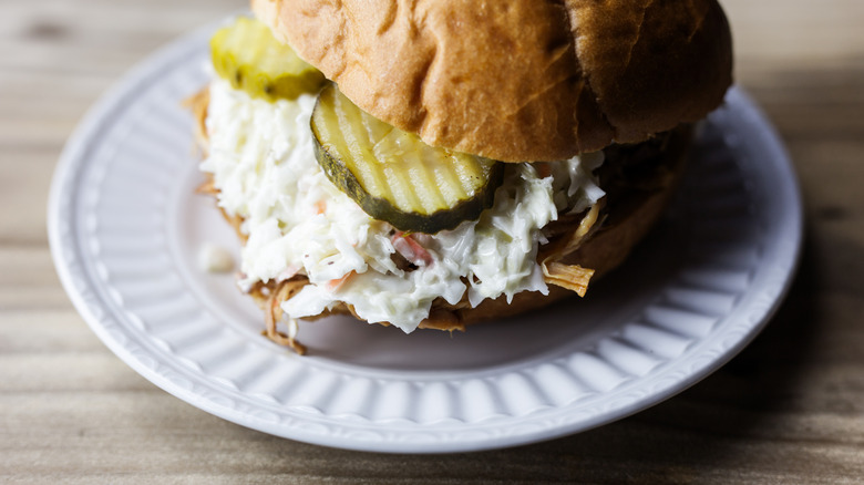BBQ sandwich with coleslaw and pickles.