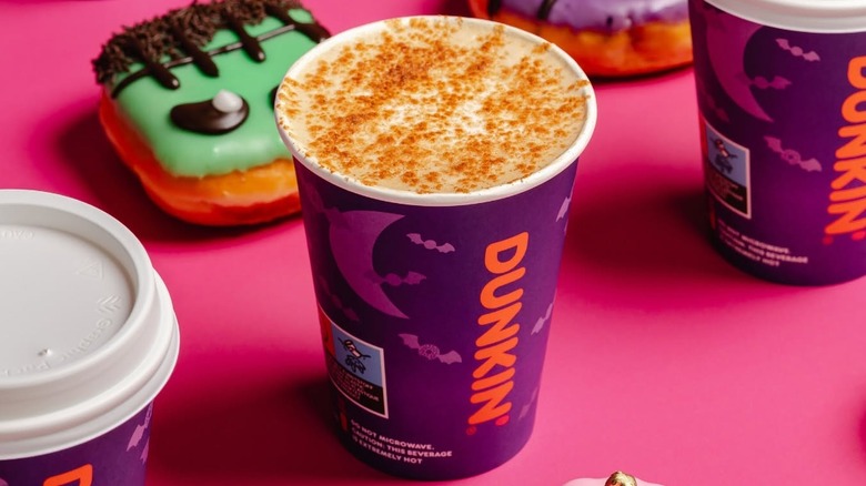 A small pumpkin spice latte from Dunkin', topped with foam and a blend of spices.