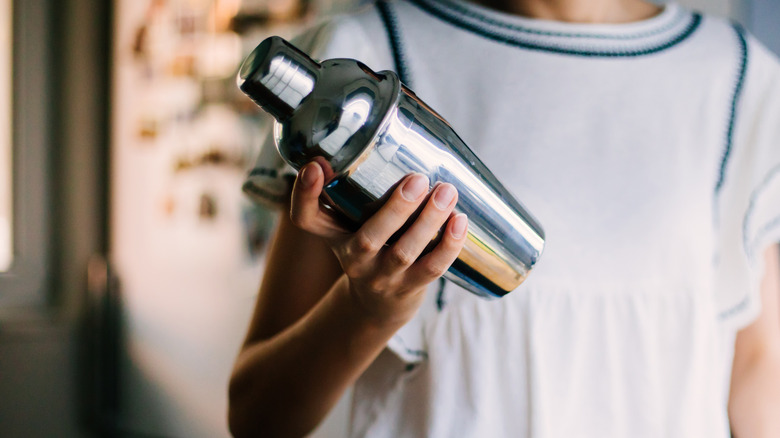 woman holding cocktail shaker