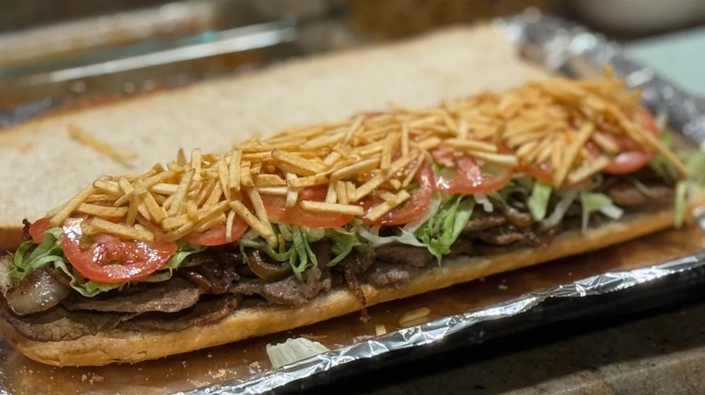 An open faced pan con bistec sandwich.