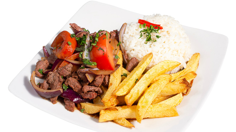 A plate of lomo saltado and white rice.