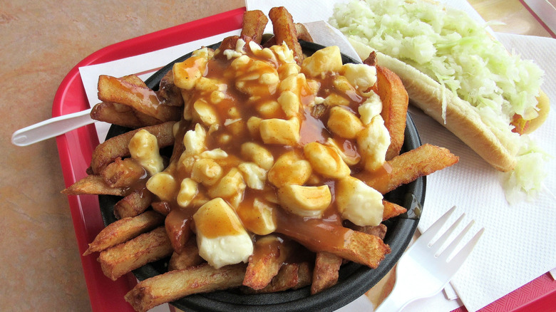 A plate of traditional poutine with a guedille on the side.