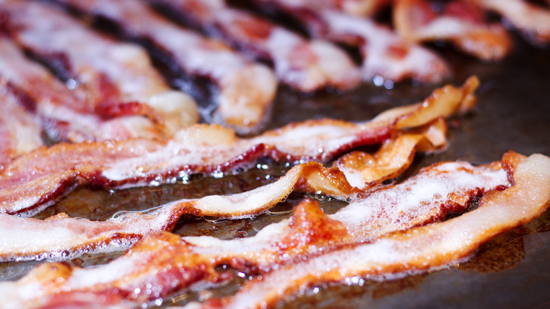 Bacon frying on a flat top grill