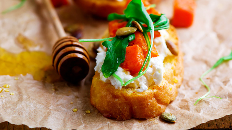 crostini topped with roasted pumpkin, nuts, and honey