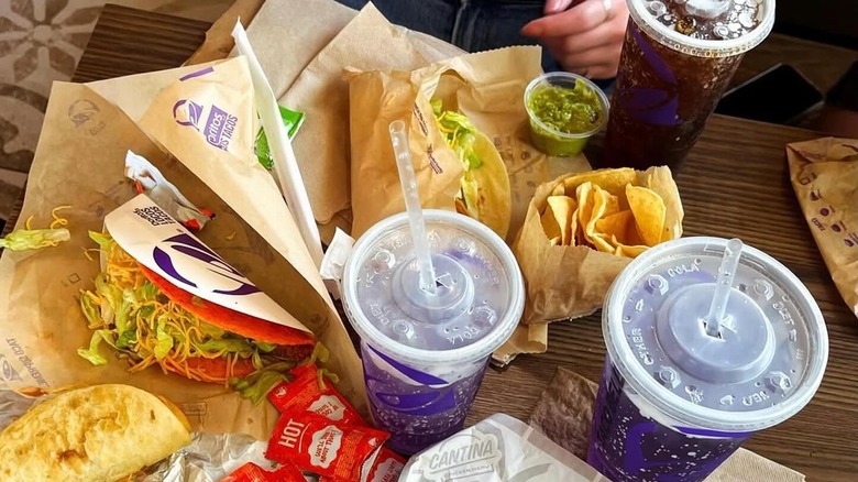Taco Bell tacos and drinks with a side of guacamole.