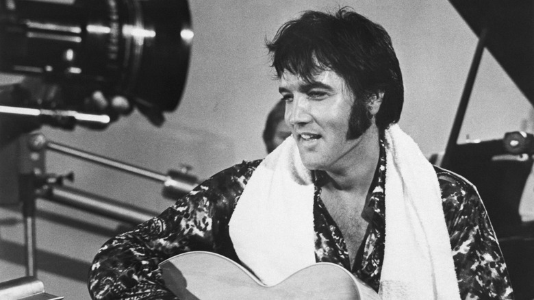 Elvis Presley playing guitar on a TV set