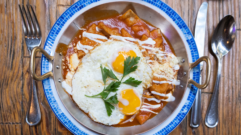 chilaquiles with enchilada sauce with fried egg and cilantro