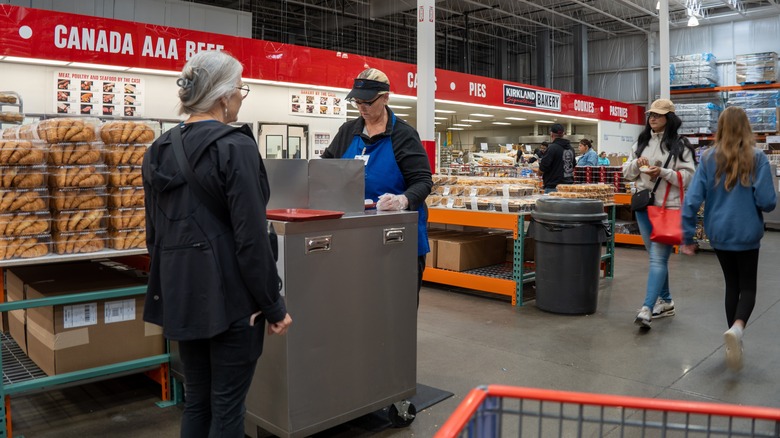 A Costco employee giving out samples to customer