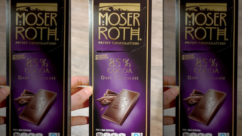 Hand holding dark chocolate bar