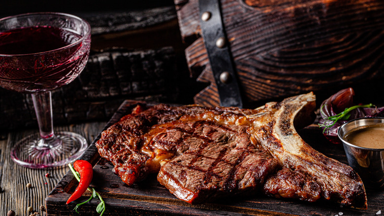 grilled steak next to glass of red wine