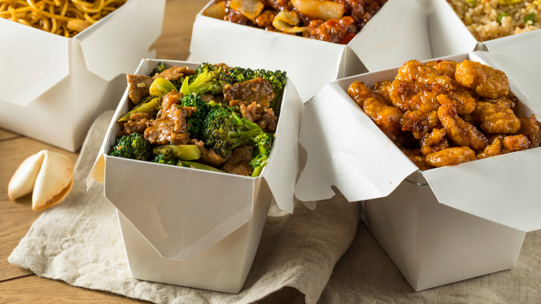 boxes of takeout Chinese food and a fortune cookie