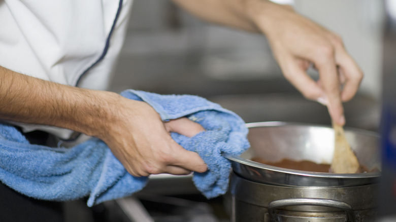 Chef gripping bowl with towel