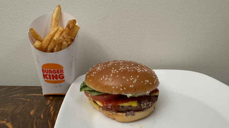 Whopper on plate next to Burger King soft drink
