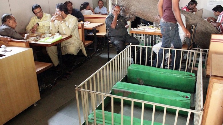 People eating next to coffins in restaurant