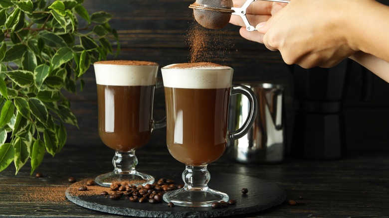 sprinkling cocoa on irish coffee