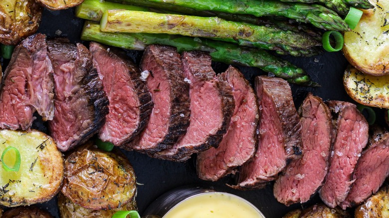 Teres major cut and spread out, surrounded by potatoes and asparagus
