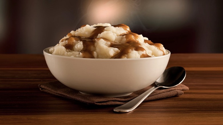 Bowl of KFC mashed potatoes and gravy with a spoon on a napkin