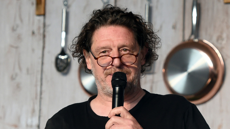 Marco Pierre White speaks into a microphone during a demonstration