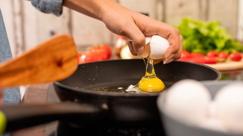 cracking egg into a skillet