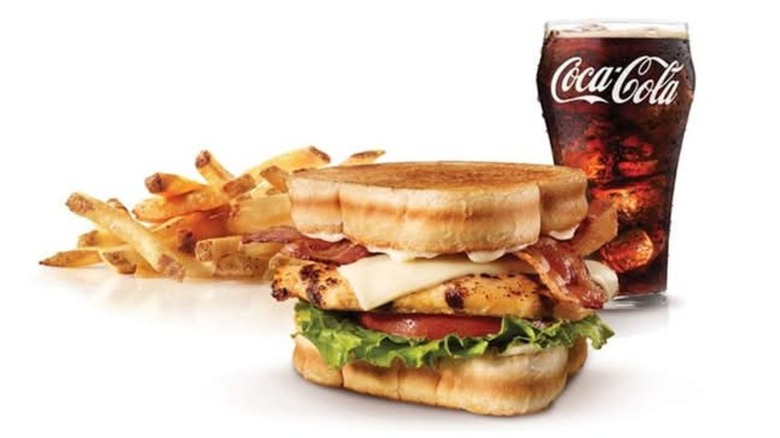 A Carl's Jr. Charbroiled Chicken Club sandwich with french fries and a Coke.