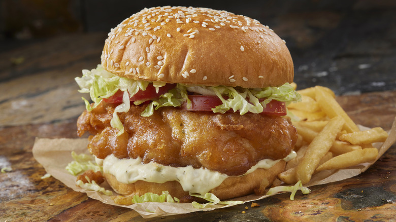 A crispy fried fish sandwich with fries