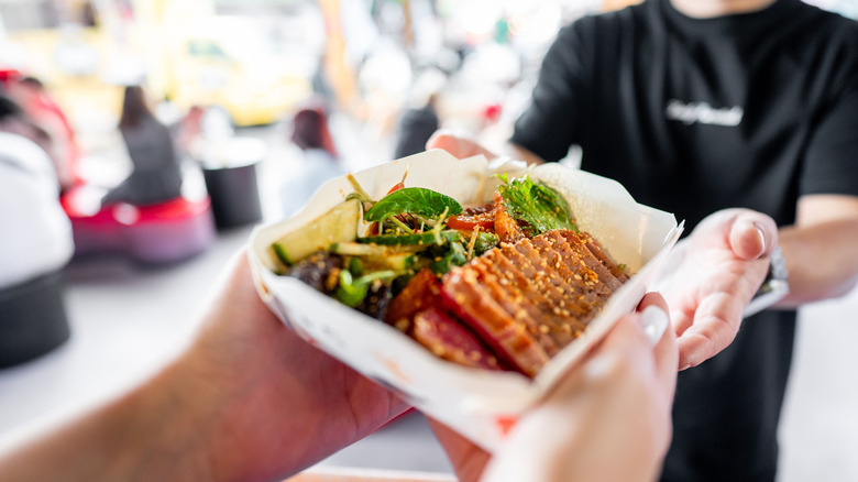A person being handed food over a counter