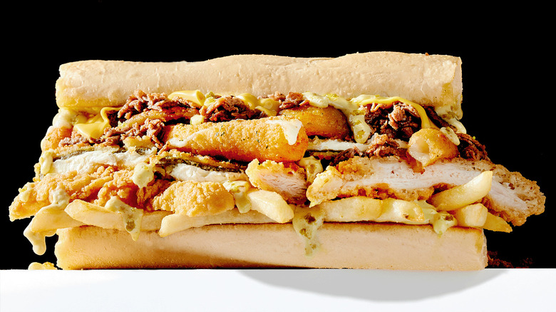 Image of a Fat Shack sandwich stuffed with fries, chicken, mozzarella sticks, and more