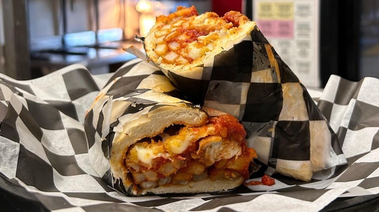 Stacked halves of a Fat Shack sandwich on checkered paper
