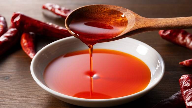 chili oil dripping off spoon into bowl