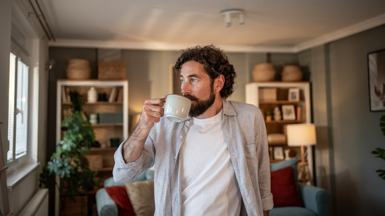 Man drinking coffee and looking out the window