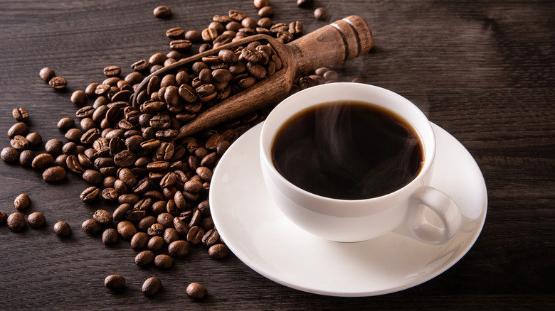 A cup of coffee with coffee beans