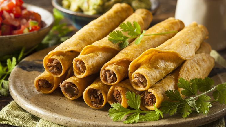 A plate of taquitos garnished with parsley