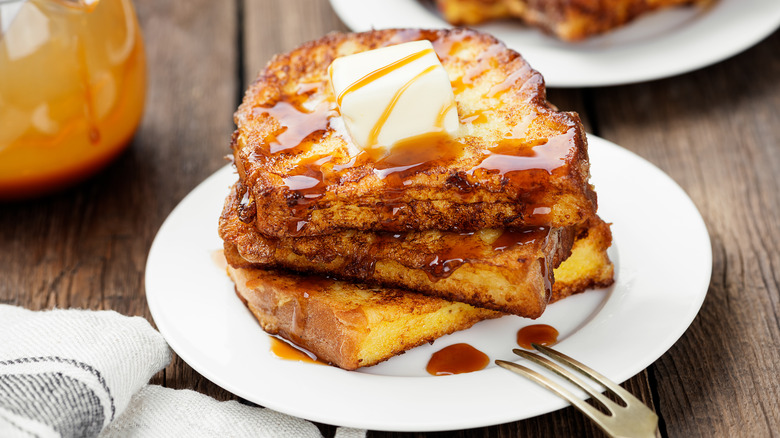 Fluffy French toast on a plate with butter and syrup