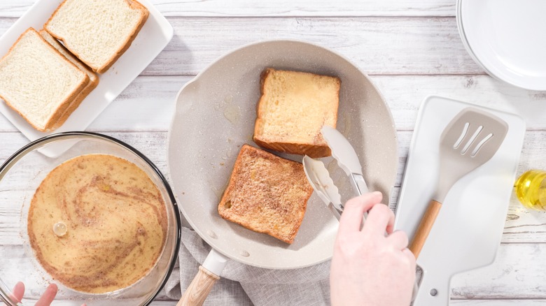 Cooking French toast dipped in batter in a pan