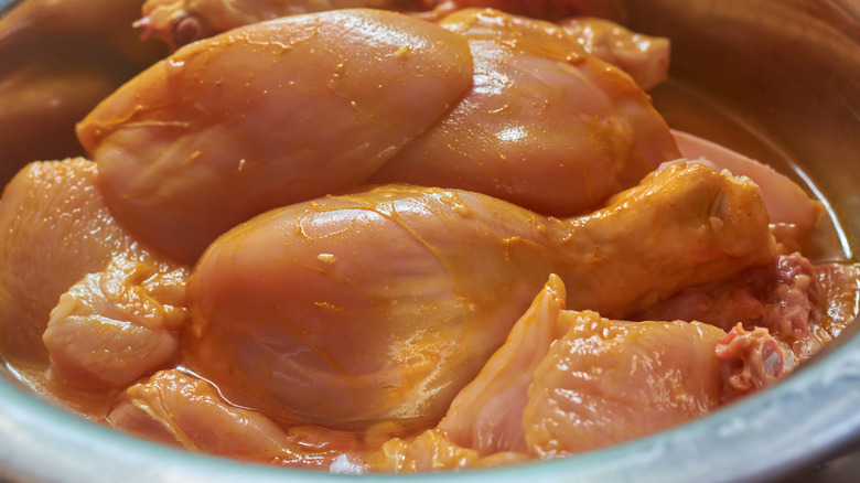 Chicken marinating in a bowl.