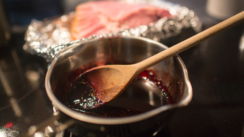 A glaze being prepared with ham in the background.